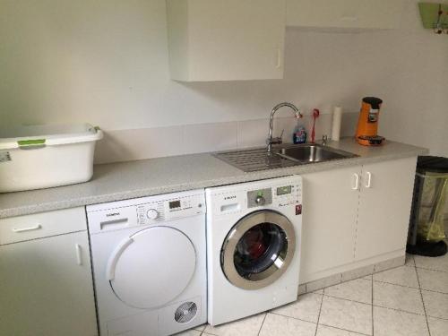 a kitchen with a washing machine and a sink at Moderne-Ferienwohnung-in-ruhiger-Lage in Quickborn