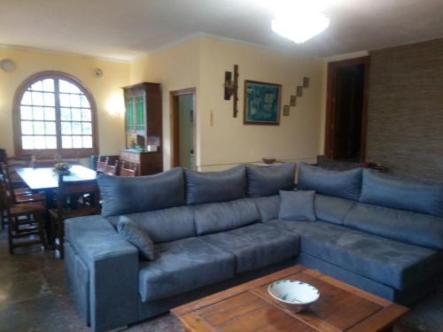 a living room with a blue couch and a table at Los Tobares in Gárgoles de Arriba