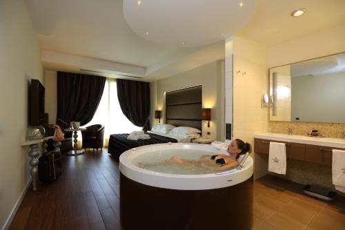 een vrouw in een bad in een hotelkamer bij Fonte Del Benessere Resort in Castelpetroso