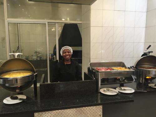 a man standing in front of a mirror in a kitchen at Cranberry Cottage in Ladybrand