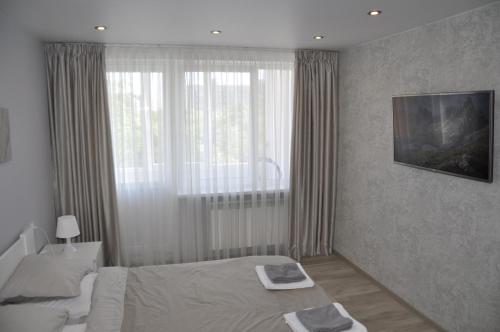カリーニングラードにあるАпартаменты на нижнем озереのベッドルーム1室(ベッド1台、大きな窓付)