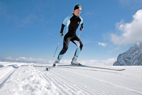 a woman is skiing down a snow covered slope at Apartment Aschaber in Waidring
