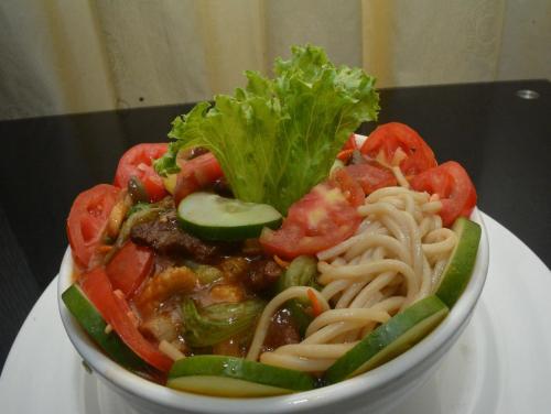 a bowl of pasta and vegetables on a table at Eusbett Hotel in Sunyani
