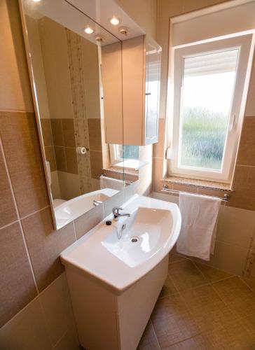 a bathroom with a sink and a tub and a mirror at Apartments Villa Kristina in Supetarska Draga
