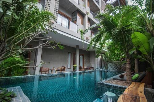 a swimming pool in the middle of a building with trees at Sarina Boutique Hotel in Phnom Penh