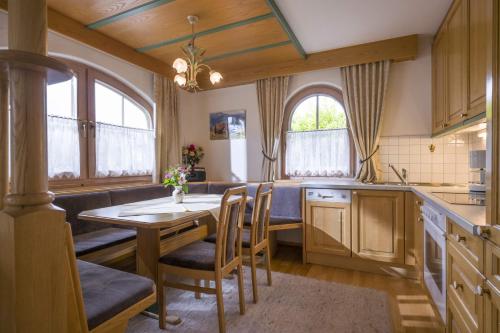 a kitchen with a table and chairs and windows at Ferienhaus Elisabeth in Ellmau