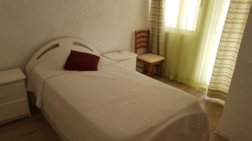 1 dormitorio con cama blanca y almohada roja en Villa in Le Tamier, 4 bedrooms, 300m Flic en Flac beach, en Flic en Flac