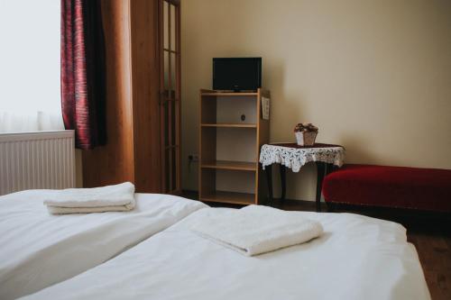 1 dormitorio con 2 toallas blancas en una cama en SZÉP KERT VENDÉGHÁZ, en Szekszárd