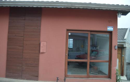 a red house with a glass door on the side of it at 50 Hotel in Extrema