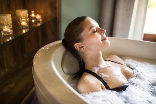 a woman is sitting in a bath tub at Wellness Hotel Happy Star in Hnanice