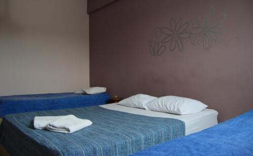 two beds in a room with towels on them at 50 Hotel in Extrema
