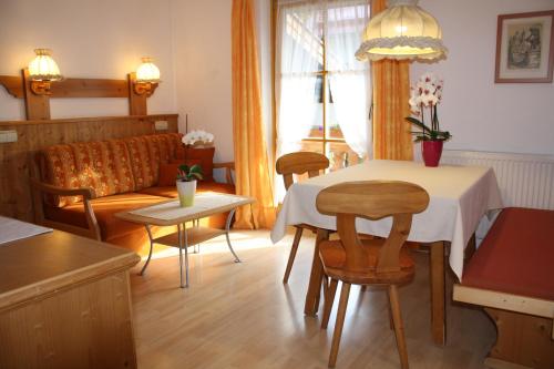 a living room with a table and chairs and a couch at Haus Alpenlicht in Reit im Winkl