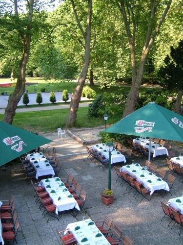 a group of tables and chairs with umbrellas at Hotel Haus Hohenstein in Witten