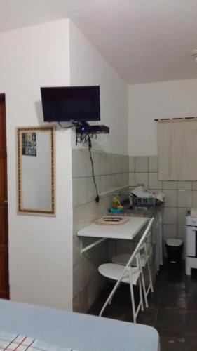 una pequeña cocina con mesa y espejo en Pousada Recanto das Tartarugas, en Maresias
