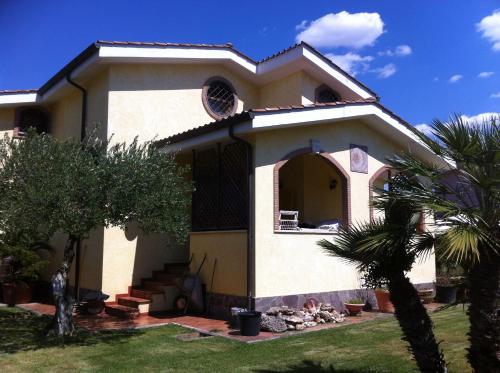 a house with a palm tree in front of it at Paoline's suite in villa in Fiumicino