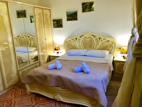 a bedroom with a large bed with blue pillows at RAMIS Hotel & Outdoor Sports Center in Përmet