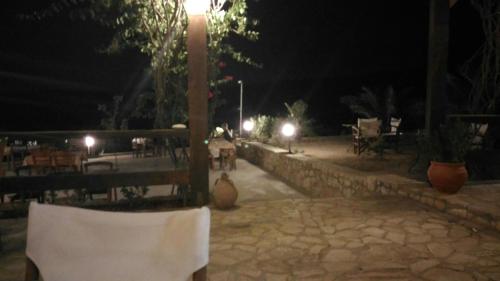 a patio at night with a table and chairs at Gavdos Princess in Gavdos