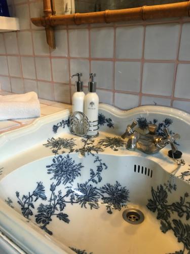 a blue and white sink with two bottles on it at Muller's Bed & Breakfast in Bargemon