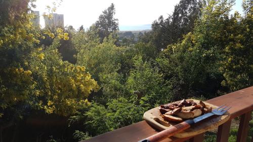 a bowl of food sitting on a wooden bench at Pao Pao Lodge Algarrobo in Algarrobo