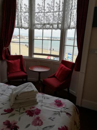 a bedroom with a bed and a view of the beach at Cavendish House in Weymouth