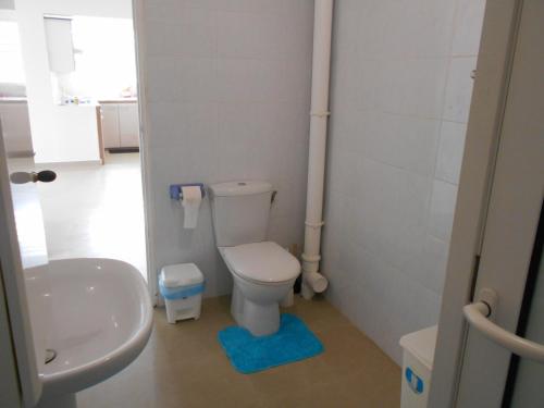 a bathroom with a toilet and a sink at VillaFleurie in Le Gosier