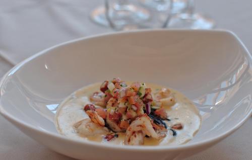 a white bowl of food with shrimp on top at Oleander Guest House in Kimberley