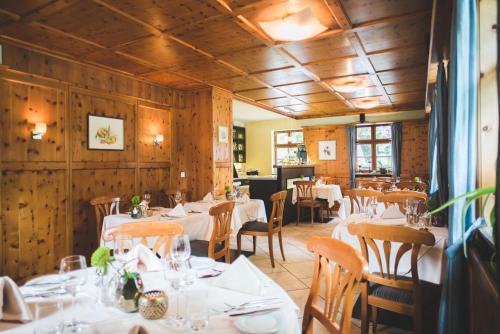 un restaurante con mesas y sillas blancas y paredes de madera en Hotel Zirbelstube en Núremberg