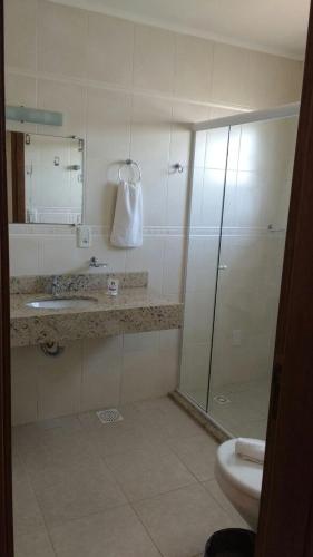 a bathroom with a shower and a sink and a toilet at Hotel Recanto do Imperador in Rio Pardo