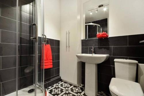 La salle de bains est pourvue d'un lavabo, de toilettes et d'une douche. dans l'établissement Midtown London Apartment, à Londres