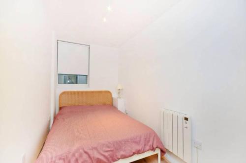 - une petite chambre avec un lit et une fenêtre dans l'établissement Midtown London Apartment, à Londres