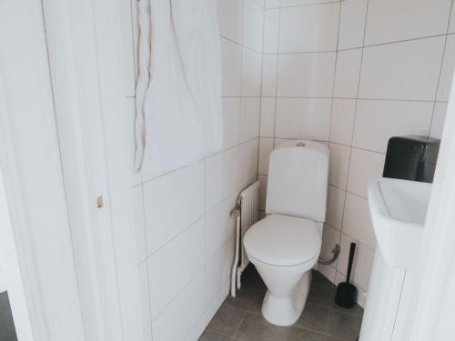 a white bathroom with a toilet and a sink at Arboga Stadshotell in Arboga