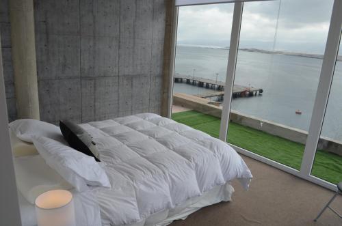1 dormitorio con cama grande y ventana grande en Departamento Bahia Caldera, en Caldera