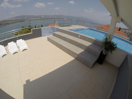 a large swimming pool with a balcony overlooking the ocean at Apartments Exclusive Palace in Trogir