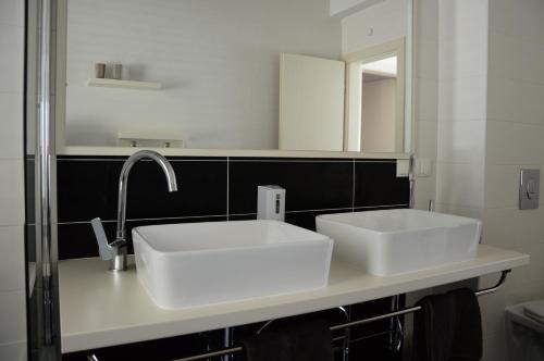 een badkamer met 2 witte wastafels en een spiegel bij Apartments Exclusive Palace in Trogir