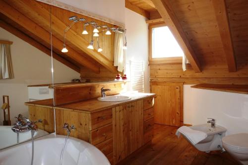 a bathroom with a white tub and a toilet at Chesa il Rifugio 1 in St. Moritz