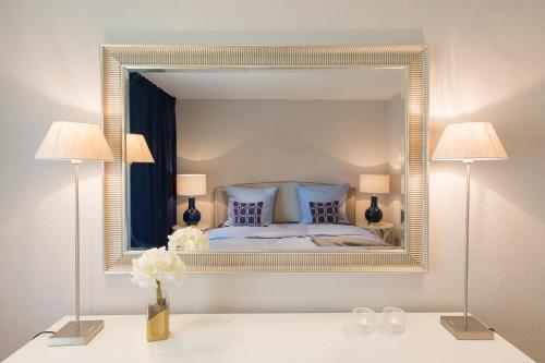 ein Schlafzimmer mit einem großen Spiegel an der Wand in der Unterkunft Abnoba Mons Design Apartment Lenzkirch in Lenzkirch