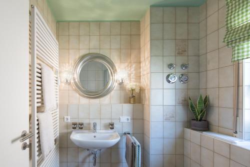 a bathroom with a sink and a mirror at Abnoba Mons Design Apartment Lenzkirch in Lenzkirch