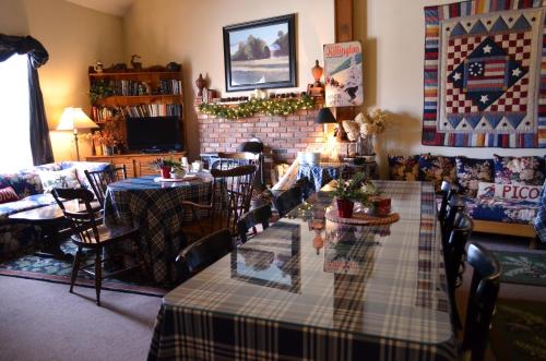 een woonkamer met een tafel en stoelen en een open haard bij Greenbrier Inn Killington in Killington