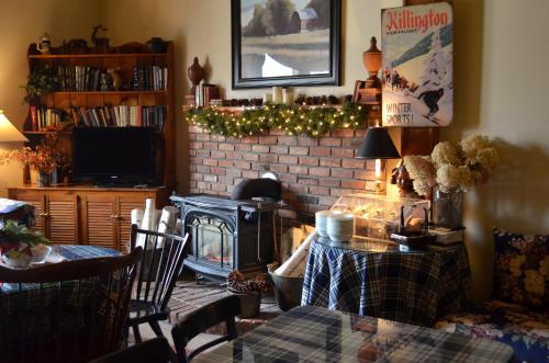 a living room with a fireplace and a table and chairs at Greenbrier Inn Killington in Killington