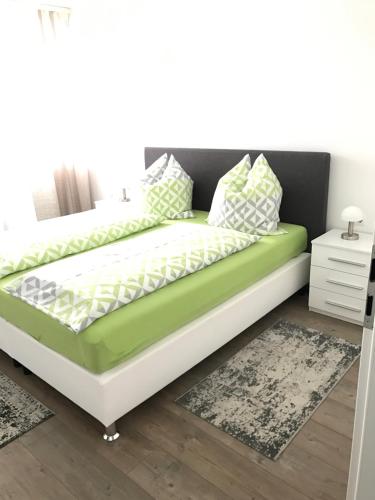 ein grün-weißes Bett in einem Zimmer in der Unterkunft City Apartment in Augsburg
