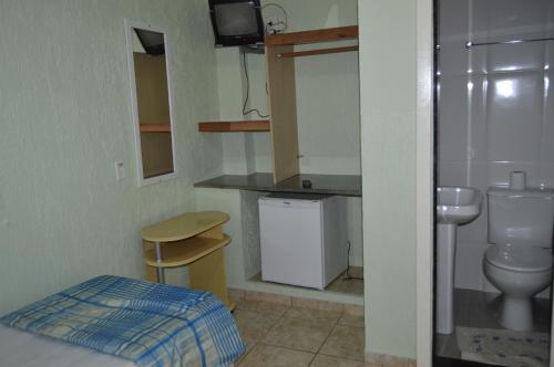 La petite salle de bains est pourvue de toilettes et d'un lavabo. dans l'établissement Hospedagem Belo Horizonte, à Macaé