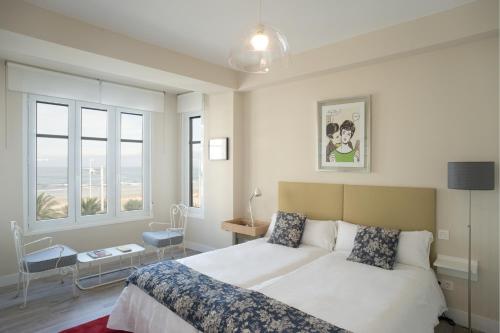 サン・セバスティアンにあるSan Diego - Iberorent Apartmentsのベッドルーム1室(白いベッド1台、窓2つ付)