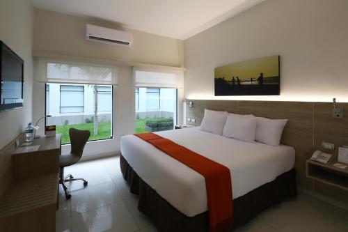 una camera d'albergo con letto, scrivania e finestra di Casa Andina Standard Piura a Piura