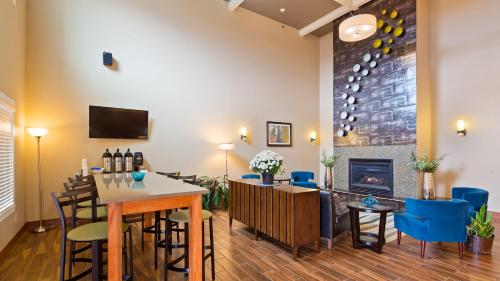 a living room with a fireplace and a table and chairs at BEST WESTERN Plus Menomonie Inn & Suites in Menomonie
