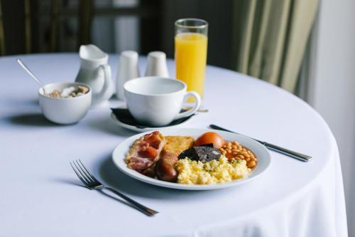 ein Teller mit Frühstücksessen auf einem Tisch mit Orangensaft in der Unterkunft Dunedin Country House in Patrington