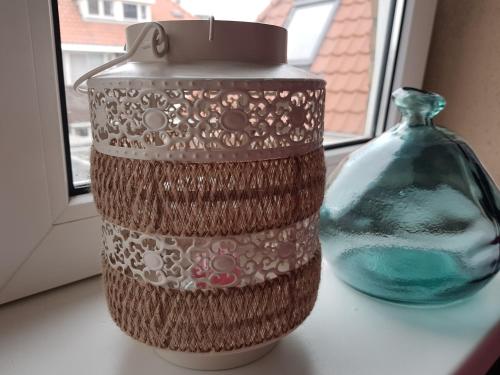 a container and a vase sitting on a table at Evy's place in Zandvoort
