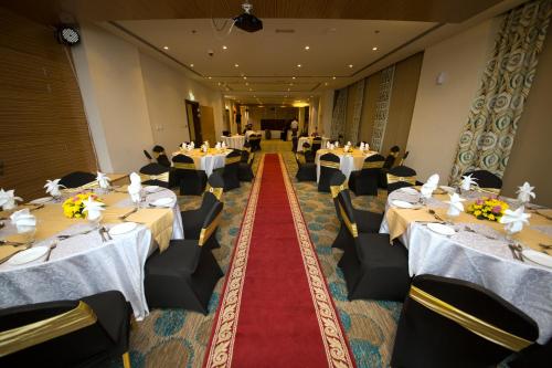 a banquet hall with tables and chairs with a red carpet at Best Western Plus Pearl Creek in Dubai