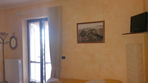 a room with a window and a television on a wall at Civita Nova in Bagnoregio