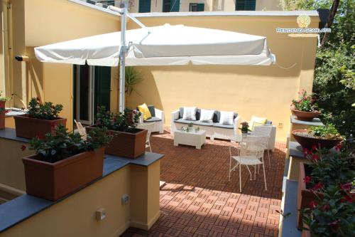 um pátio exterior com um guarda-chuva branco e plantas em Residenza Scarlatti em Nápoles