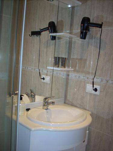 een badkamer met een toilet, een wastafel en een spiegel bij Marina Nova in Cedeira